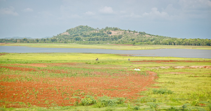 Mực nước hồ Ea Kao đang ở mức thấp để lộ những doi đất đỏ quanh mặt hồ 
